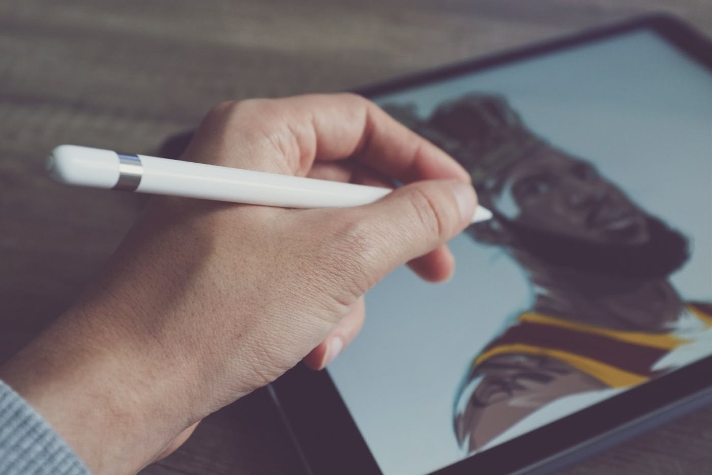 person holding apple pen on pad